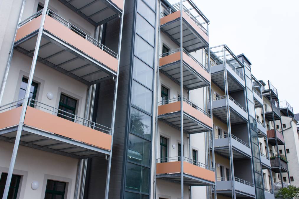 Balkonanlagen an Mehrfamilienhaus mit Balkotec-Balkonplattenbelag und Geländer mit Füllung aus Verkleidungsplatten.