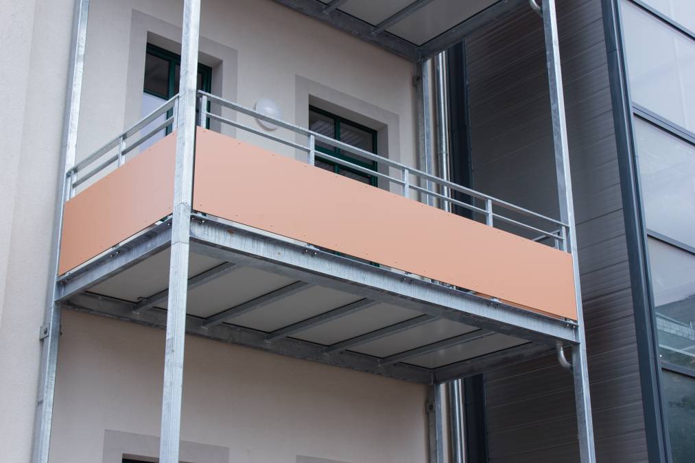 Balkonanlagen an Mehrfamilienhaus mit Balkotec-Balkonplattenbelag und Geländer mit Füllung aus Verkleidungsplatten.