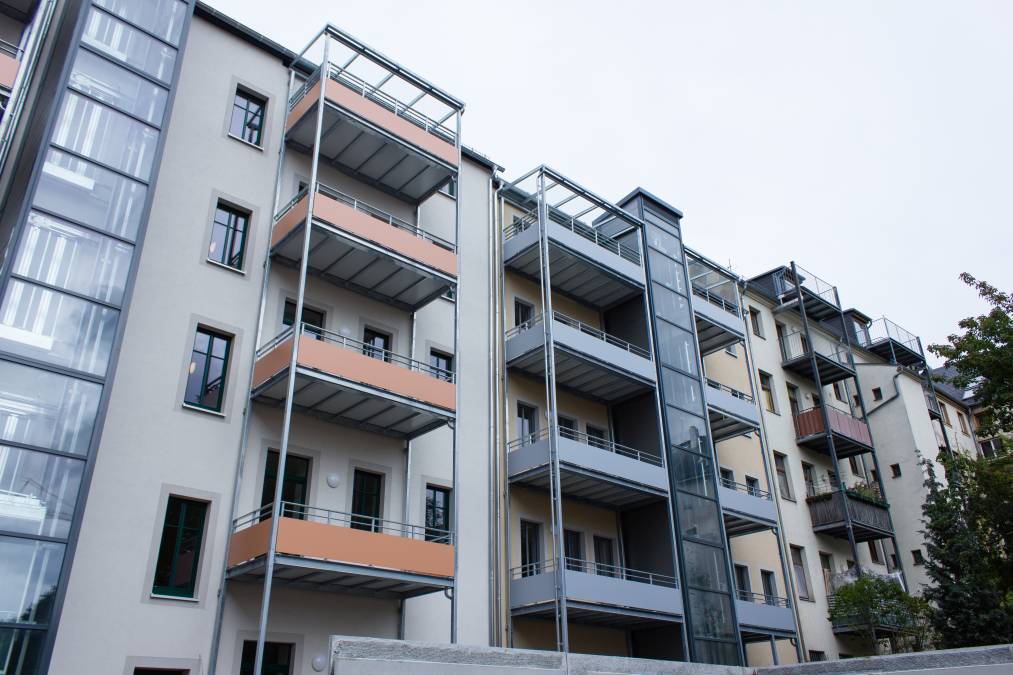 Balkonanlagen an Mehrfamilienhaus mit Balkotec-Balkonplattenbelag und Geländer mit Füllung aus Verkleidungsplatten.