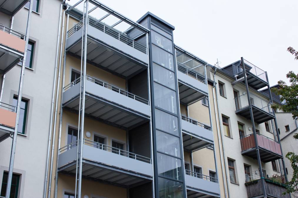 Balkonanlagen an Mehrfamilienhaus mit Balkotec-Balkonplattenbelag und Geländer mit Füllung aus Verkleidungsplatten.