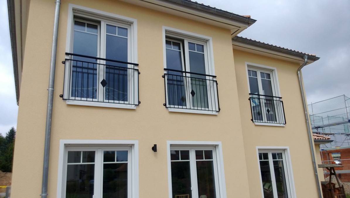 Balkongeländer und französische Fenstergitter an einem Einfamilienhaus