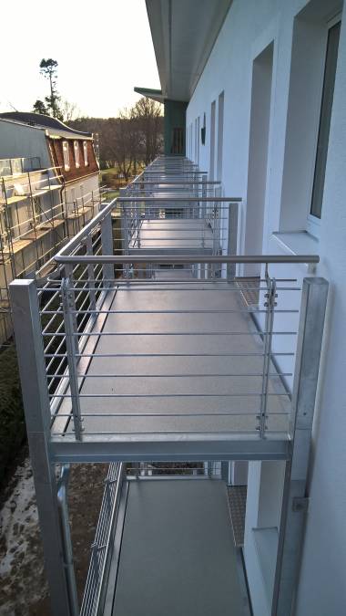 Balkonanlagen an Hotel in Kühlungsborn, mit Balkotec Balkonplattenbelag, Geländer mit horizontalen Füllstäben und Edelstahlhandlauf.