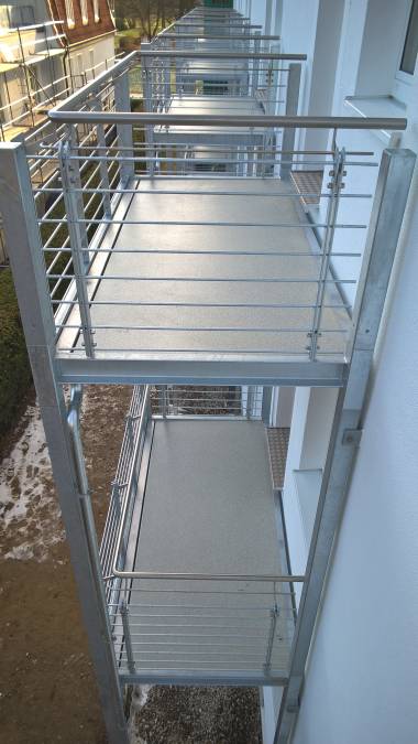 Balkonanlagen an Hotel in Kühlungsborn, mit Balkotec Balkonplattenbelag, Geländer mit horizontalen Füllstäben und Edelstahlhandlauf.