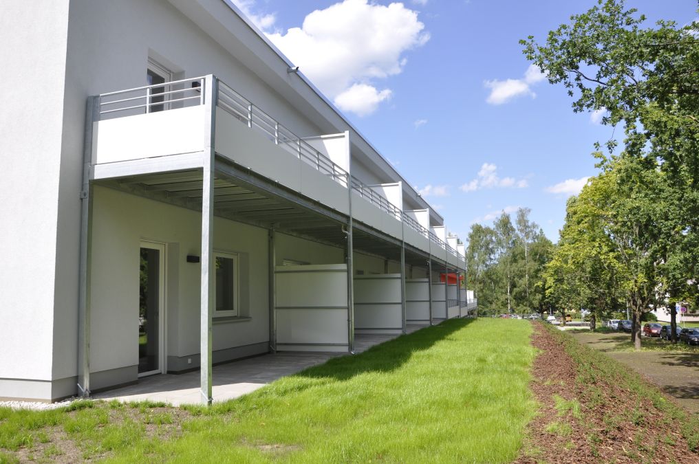 Laubengänge mit Glasüberdachung und Balkone an einem Wohnhaus