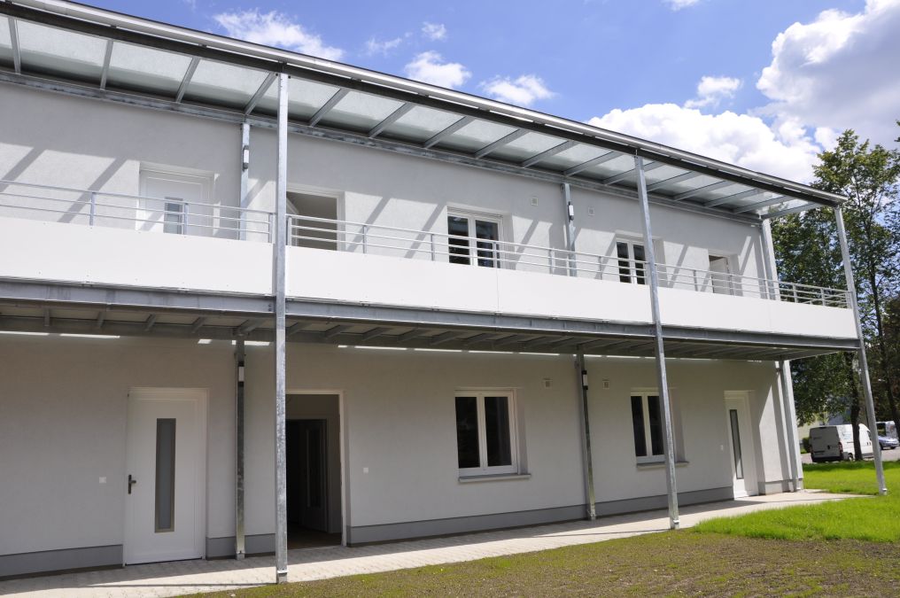 Laubengänge mit Glasüberdachung und Balkone an einem Wohnhaus